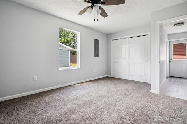 unfurnished bedroom featuring carpet, electric panel, and a textured ceiling