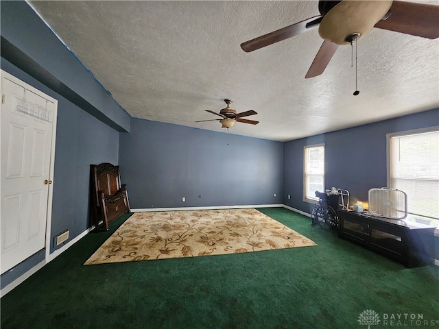 miscellaneous room featuring a textured ceiling, ceiling fan, and dark carpet