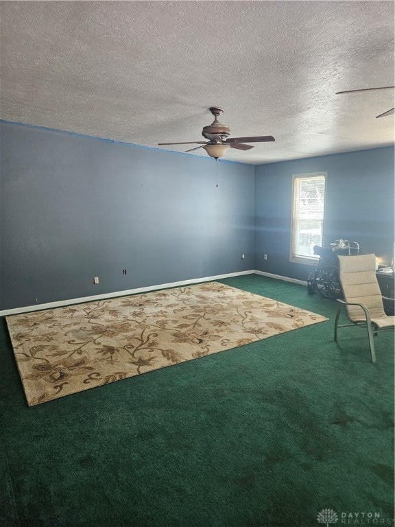 unfurnished room featuring carpet floors, a textured ceiling, and ceiling fan