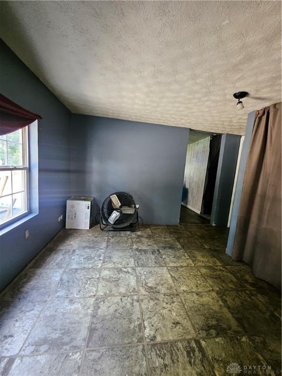 empty room featuring lofted ceiling and a textured ceiling