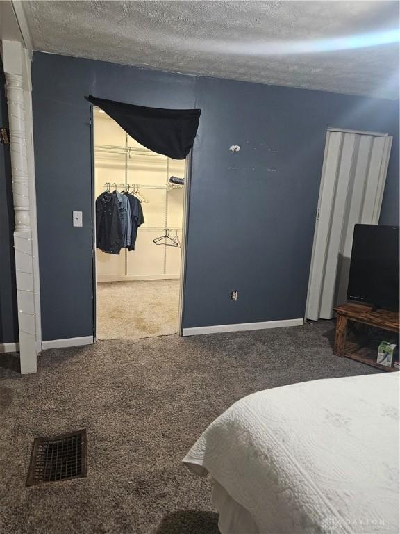 bedroom with carpet floors and a textured ceiling