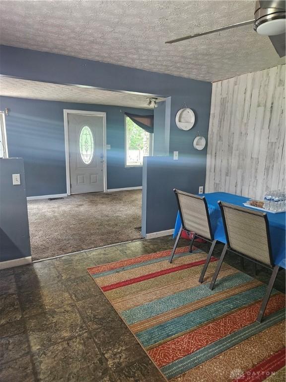 foyer with a textured ceiling and carpet flooring