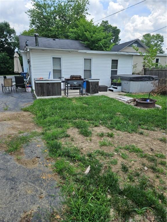 rear view of house featuring a hot tub and a patio area