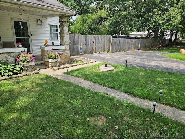 view of yard with fence, a patio, and driveway