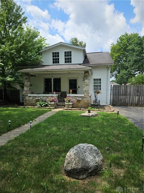 view of front of house featuring covered porch and a front yard