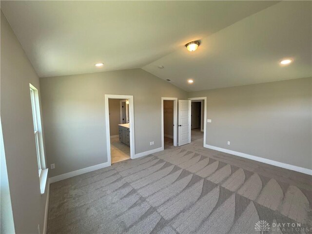 empty room featuring lofted ceiling and light carpet