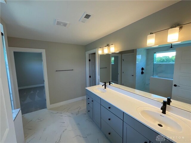 bathroom with vanity and a tile shower