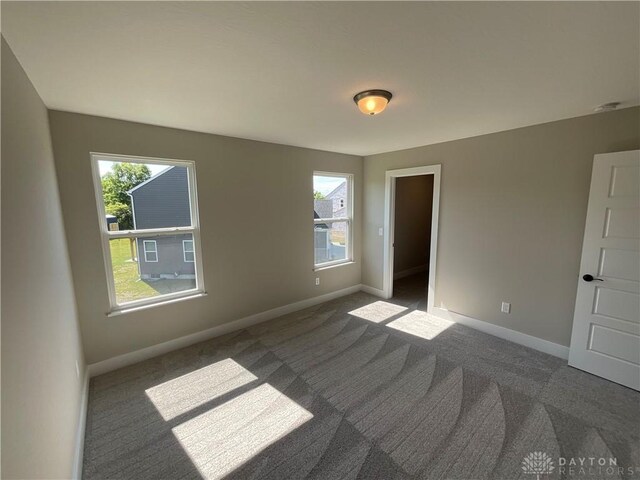 carpeted empty room with plenty of natural light