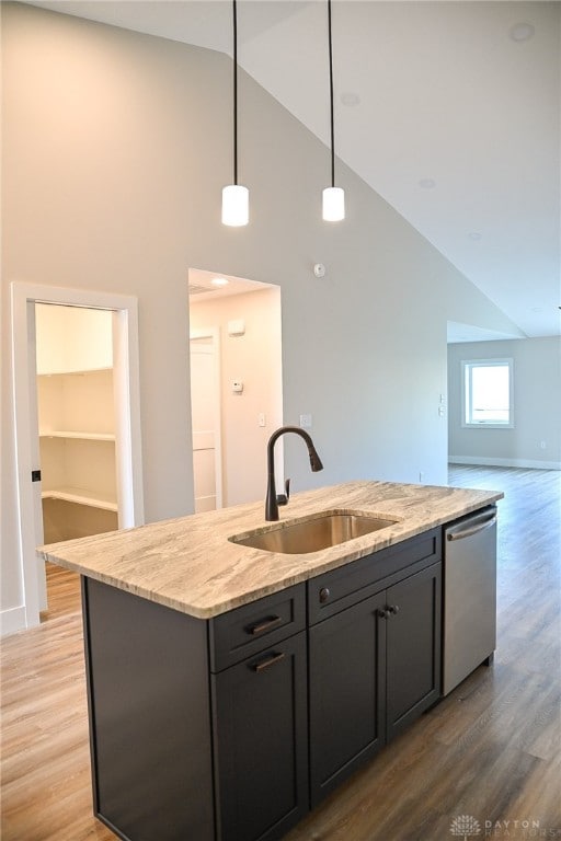 kitchen with dishwasher, light hardwood / wood-style flooring, an island with sink, sink, and high vaulted ceiling