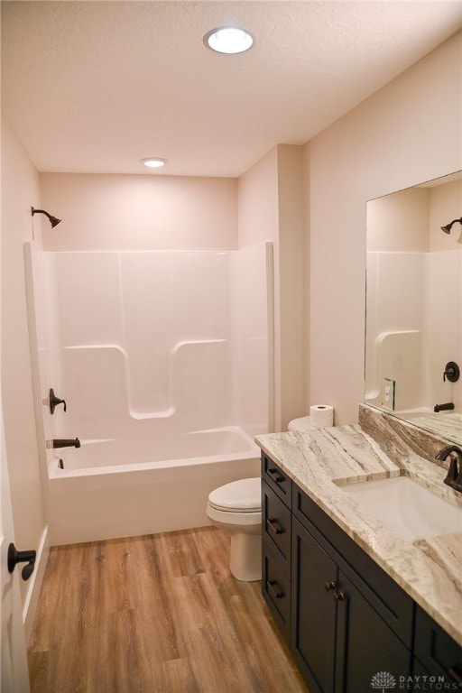 full bathroom with vanity, hardwood / wood-style floors, shower / tub combination, and toilet