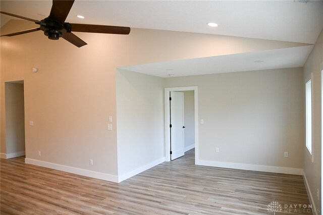 spare room with vaulted ceiling, light wood-type flooring, and ceiling fan