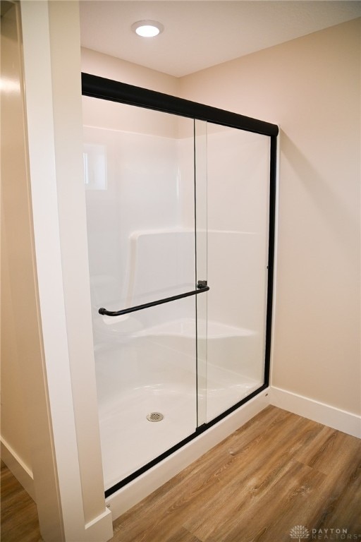 bathroom featuring an enclosed shower and hardwood / wood-style flooring