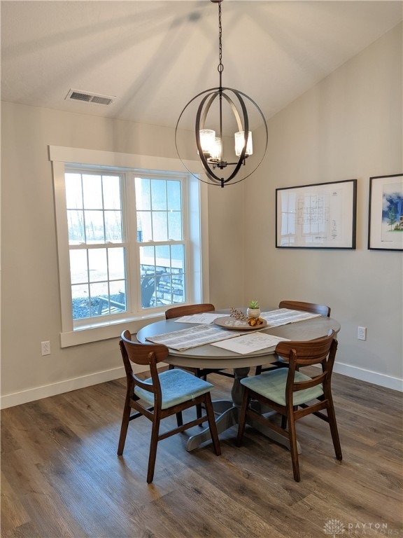 dining space featuring dark hardwood / wood-style floors and an inviting chandelier