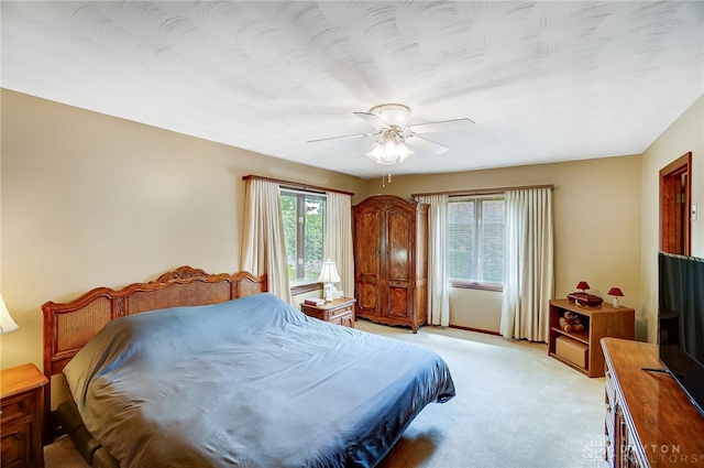 bedroom with ceiling fan and light colored carpet