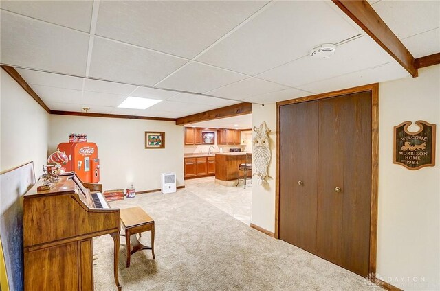 interior space featuring sink, carpet floors, and a paneled ceiling