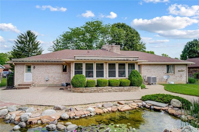 back of property with cooling unit and a patio