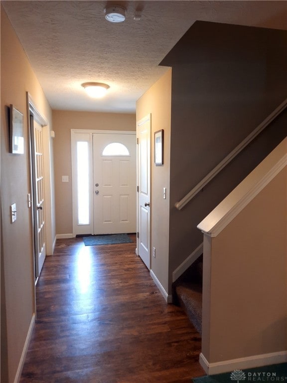 entryway featuring a textured ceiling and dark wood-type flooring