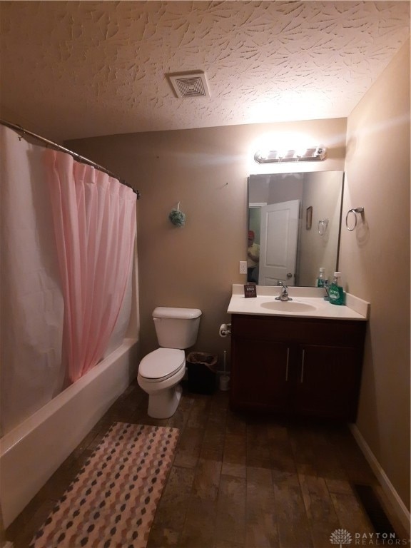 full bathroom with shower / bath combo with shower curtain, vanity, a textured ceiling, wood-type flooring, and toilet