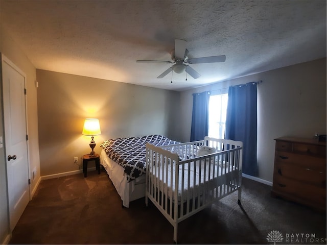 carpeted bedroom featuring ceiling fan and a textured ceiling