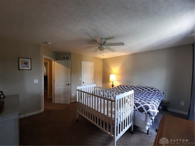 bedroom with dark carpet, ceiling fan, and a textured ceiling