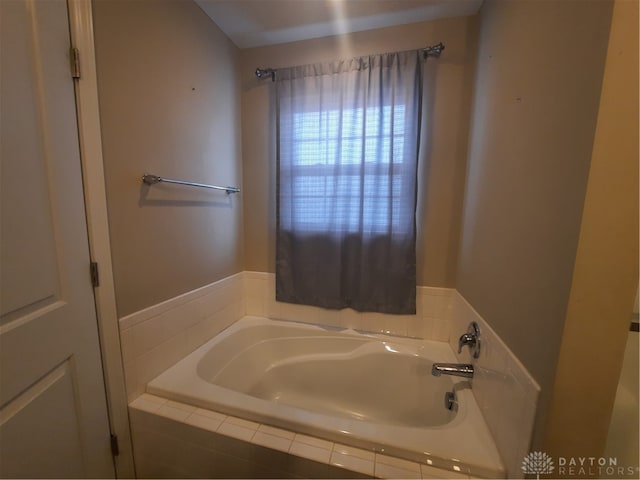 bathroom with a relaxing tiled tub