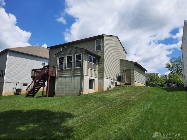 rear view of property with a lawn, a wooden deck, and central air condition unit