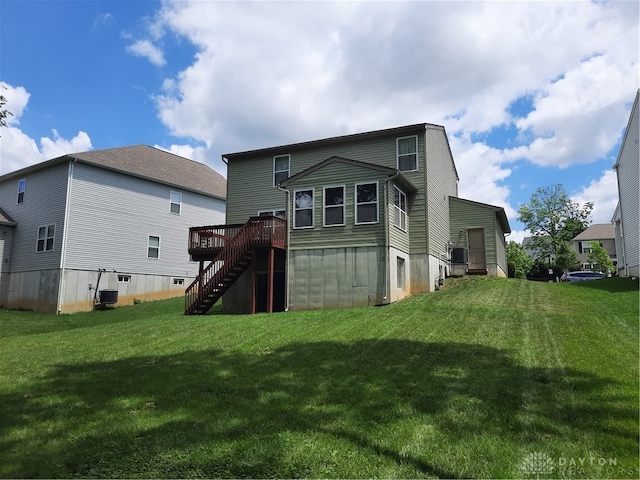 rear view of house with central air condition unit, a deck, and a yard