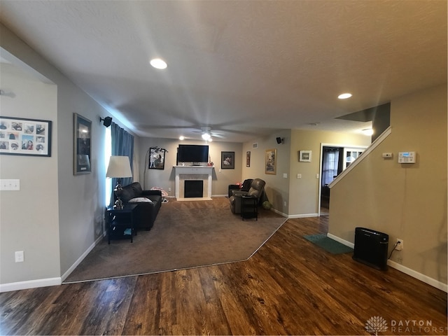 unfurnished living room with ceiling fan and dark wood-type flooring