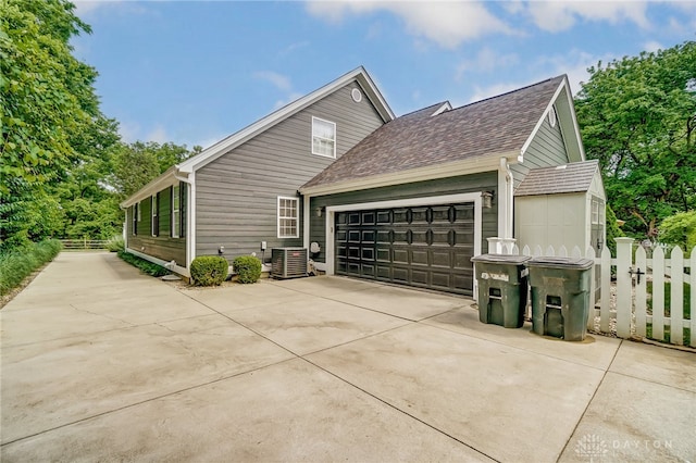 view of side of home with a garage and central air condition unit