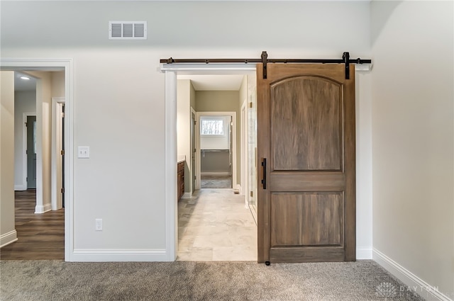 corridor featuring carpet and a barn door