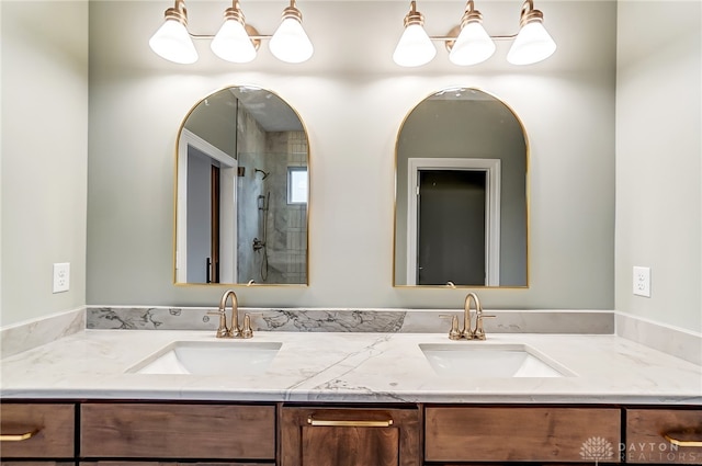 bathroom with a tile shower and vanity