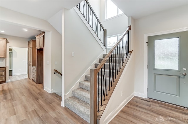 stairway with hardwood / wood-style floors and a wealth of natural light