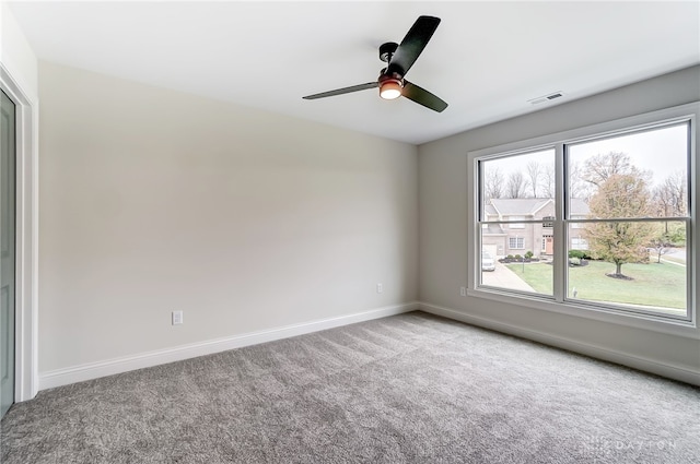 carpeted spare room featuring ceiling fan