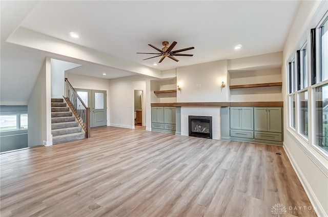 unfurnished living room featuring ceiling fan, light hardwood / wood-style floors, and a wealth of natural light