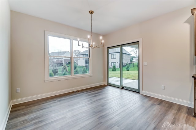 unfurnished dining area featuring hardwood / wood-style floors and a notable chandelier