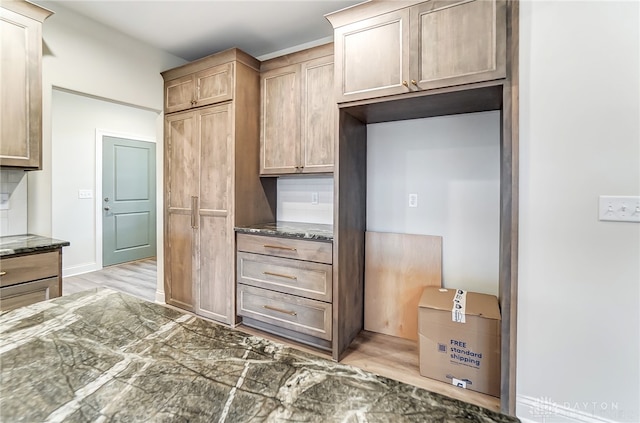 kitchen featuring tasteful backsplash and light hardwood / wood-style flooring