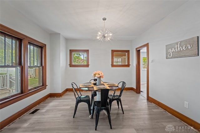 dining room with plenty of natural light, an inviting chandelier, and light hardwood / wood-style floors