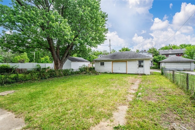 view of yard with a garage and an outbuilding