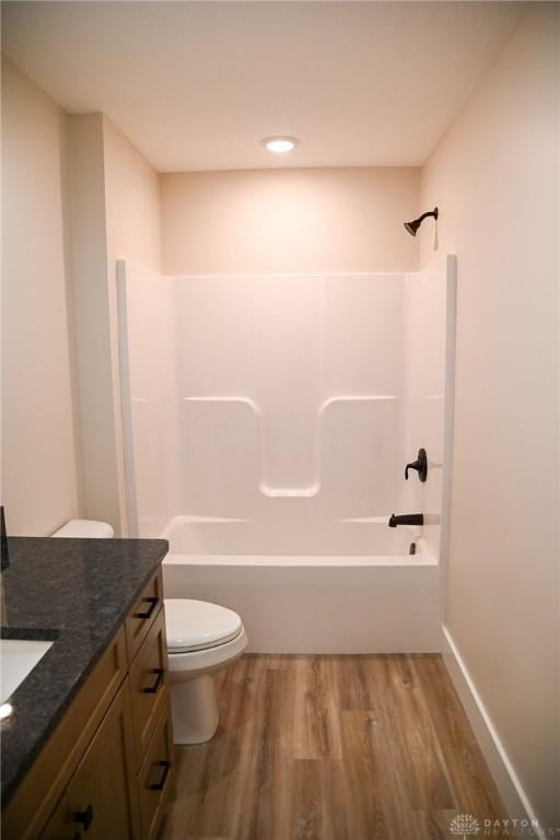 bathroom with vanity, shower / bathing tub combination, toilet, and wood finished floors