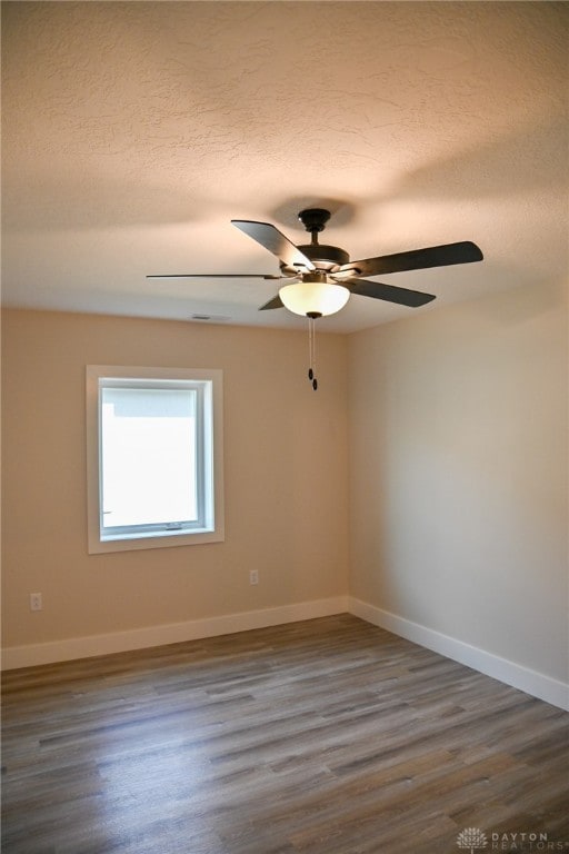 empty room featuring dark hardwood / wood-style floors, a textured ceiling, and ceiling fan