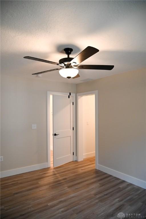 unfurnished room featuring baseboards, a ceiling fan, and wood finished floors