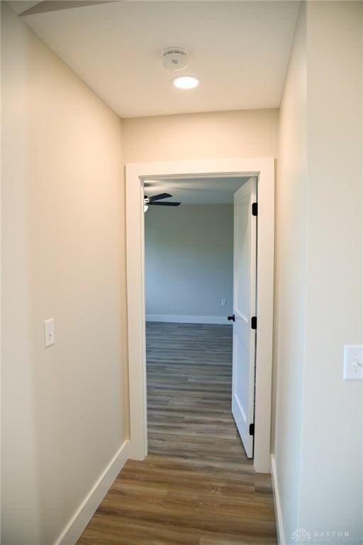 hallway with baseboards and wood finished floors