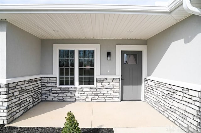 property entrance featuring stone siding and stucco siding