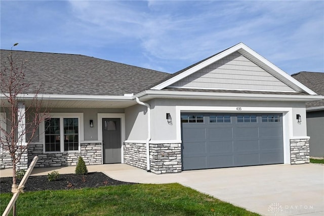 view of front of home featuring an attached garage, roof with shingles, stone siding, and concrete driveway