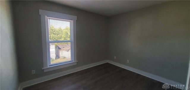 unfurnished room with dark wood-type flooring