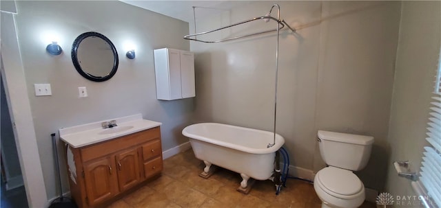 bathroom featuring a tub, vanity, and toilet