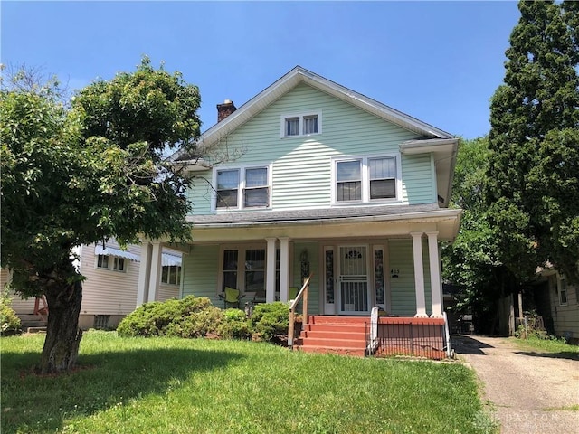 view of front facade featuring covered porch and a front yard