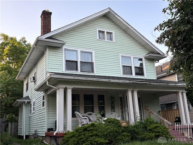 view of front of home with covered porch and a chimney