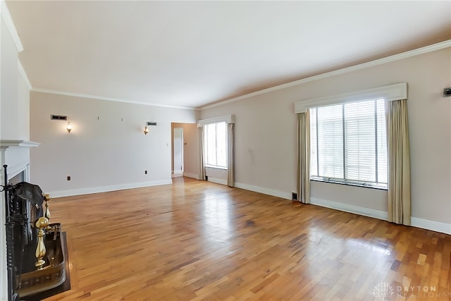 unfurnished living room featuring plenty of natural light, light wood-type flooring, and ornamental molding