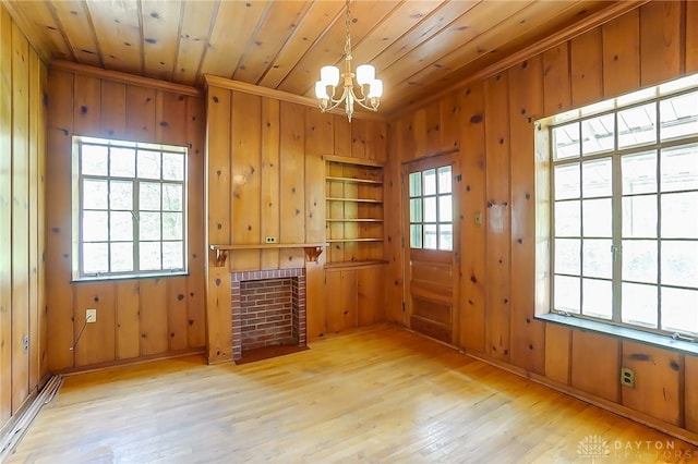 spare room featuring wood walls, wooden ceiling, plenty of natural light, and light hardwood / wood-style floors